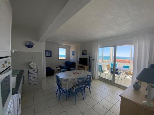Il comprend une cuisine et un salon avec une table et des chaises. dans l'établissement Grand T2 avec loggia, parking privé, proche plage et commerces - FR-1-782-54, au Barcarès