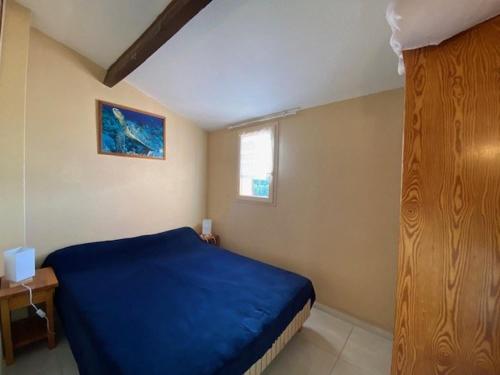 une chambre avec un lit bleu et une fenêtre dans l'établissement Appartement 2 pièces proche plage et commerces, 4 pers, Barcares - FR-1-782-47, au Barcarès