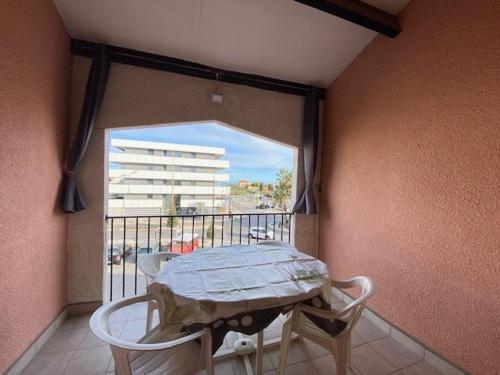 une table et des chaises sur un balcon avec une fenêtre dans l'établissement Appartement 2 pièces proche plage et commerces, 4 pers, Barcares - FR-1-782-47, au Barcarès