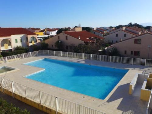 - une grande piscine dans une cour avec des maisons dans l'établissement Appartement T2 Mezzanine avec Terrasse, Piscine, Proche Plage et Commerces - Le Barcarès Village - FR-1-782-48, au Barcarès