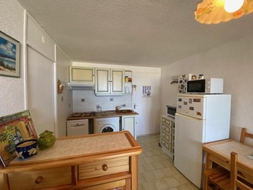 een keuken met een witte koelkast en een tafel bij Appartement Le Barcarès, 2 pièces, 4 personnes - FR-1-782-50 in Le Barcarès