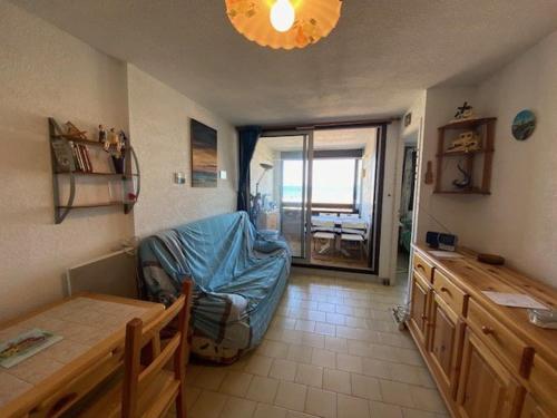 een woonkamer met een blauwe bank en een tafel bij Appartement Le Barcarès, 2 pièces, 4 personnes - FR-1-782-50 in Le Barcarès