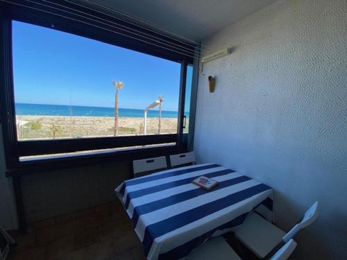 een kamer met een raam met uitzicht op het strand bij Appartement Le Barcarès, 2 pièces, 4 personnes - FR-1-782-50 in Le Barcarès