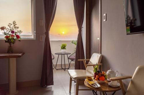 a room with a table and chairs and a window at The Up Phu Quoc in Phu Quoc