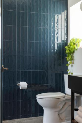 a bathroom with a toilet and a blue tiled wall at Best Bet Motor Lodge in Reno