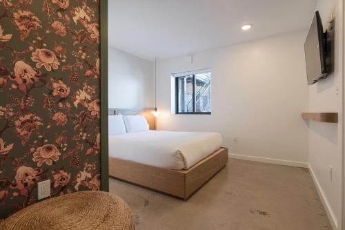 a bedroom with a bed and a wall with flowers at Best Bet Motor Lodge in Reno