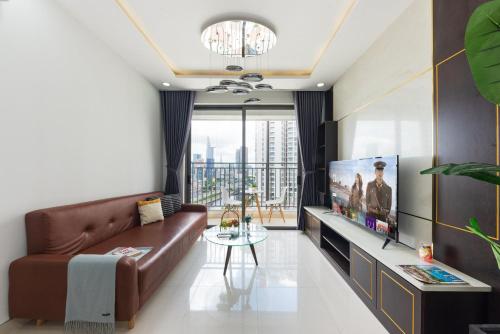 een woonkamer met een bank en een tv bij Kandy in Rivergate Luxury Apartment - near Ben Thanh market in Ho Chi Minh-stad