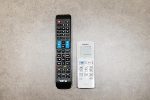two remote controls sitting next to each other on a table at Art Nagara in Osaka