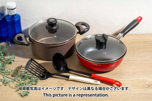 a pot and utensils on a wooden table with a sign at Art Nagara in Osaka