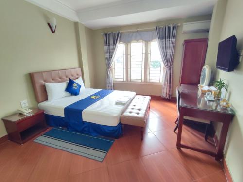 a bedroom with a bed and a table and a desk at khách sạn forever in Hanoi