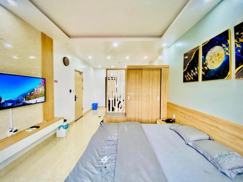 una camera con un grande letto e una TV a schermo piatto di PHƯƠNG DONG HOTEL a Ðông Khê