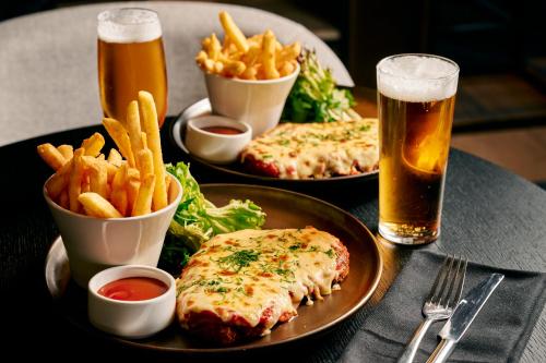 uma mesa com dois pratos de comida e batatas fritas em Hyatt Place Melbourne Essendon Fields em Melbourne