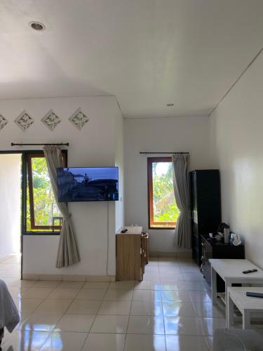 a living room with a flat screen tv on the wall at Room Five (Bhujangga’s Village) in Uluwatu