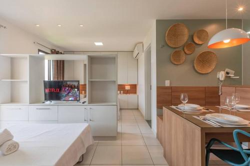 eine Küche und ein Wohnzimmer mit einem Bett und einem Tisch in der Unterkunft Vg Sun Condominio pe na areia estilo resort in Caucaia