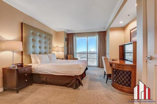 Habitación de hotel con cama, escritorio y TV. en MGM Signature-28-814 1Br 2Ba F1 Pits View Balcony, en Las Vegas