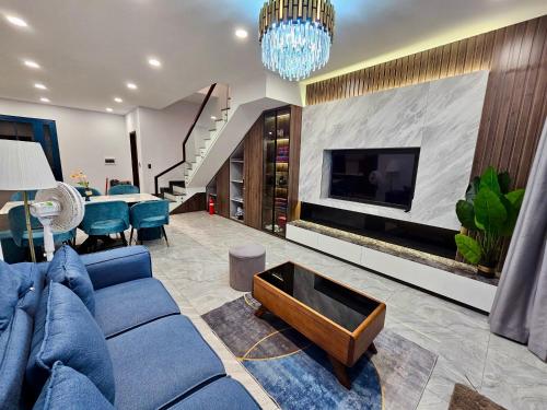 a living room with a blue couch and a fireplace at Holiday Villa Novaworld Phan Thiet in Phan Thiet