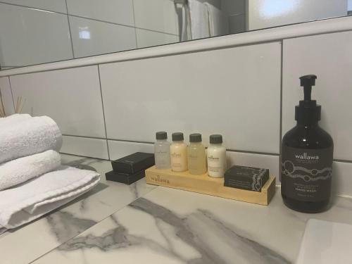 a bathroom with four bottles of soap and a mirror at Heritage Resort Shark Bay in Denham