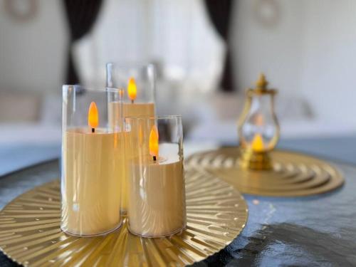 three candles on a gold plate on a table at オーシャンテラス瀬底303 in Ufugumui