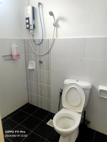 a bathroom with a toilet and a shower at Ahnaf Homestay Desaru in Bandar Penawar