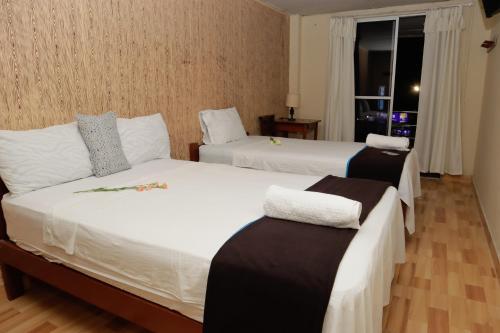 Habitación de hotel con 2 camas y ventana en Irigoin Hospedaje, en Nueva Cajamarca