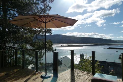 an umbrella on a deck with a view of the water at 2-Bedroom cottage in Barmouth old town with sea views in Barmouth