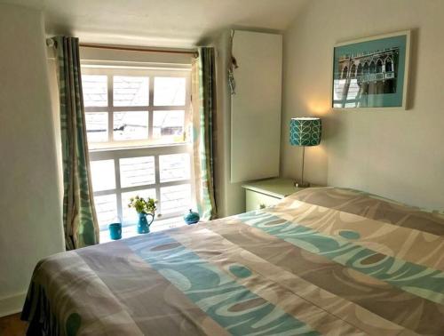 a bedroom with a bed in front of a window at 2-Bedroom cottage in Barmouth old town with sea views in Barmouth