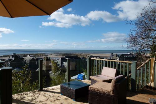 a balcony with a chair and a view of the ocean at 2-Bedroom cottage in Barmouth old town with sea views in Barmouth