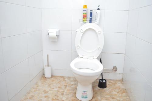 baño con aseo en un establo blanco en Air BnB Holiday Rooms, en Nairobi