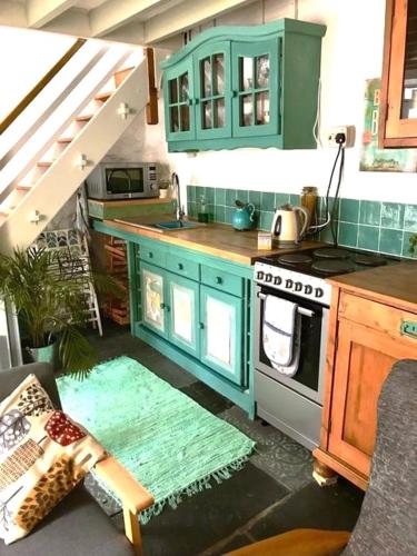 a kitchen with blue cabinets and a stove at 2-Bedroom cottage in Barmouth old town with sea views in Barmouth