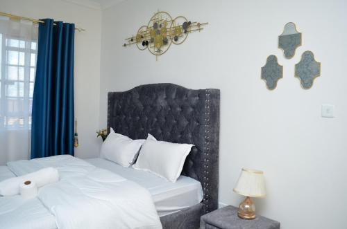 Un dormitorio con una cama con cabecero negro. en Air BnB Holiday Rooms, en Nairobi