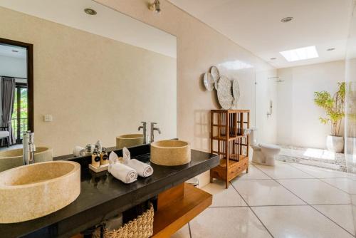 baño con 2 lavabos y espejo grande en Large, serviced villa in Berawa, Virginia Villa, en Canggu