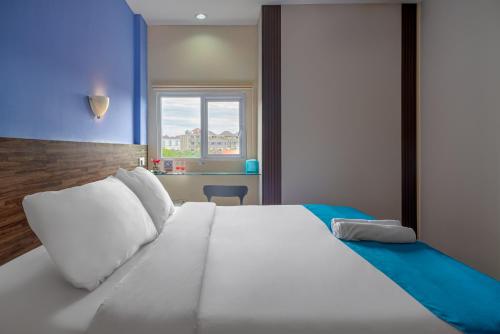 Dream @ Jimbaran في جيمباران: سرير أبيض كبير في غرفة مع نافذة