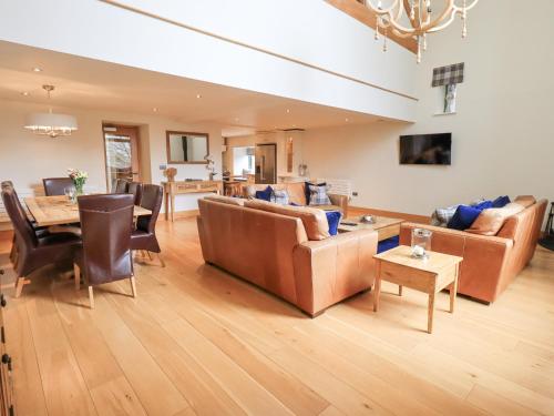 a living room with couches and a dining room at Oak Cottage in Ulverston