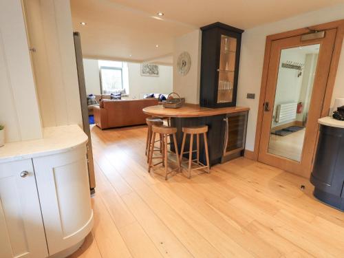 een keuken met een tafel en een woonkamer bij Oak Cottage in Ulverston