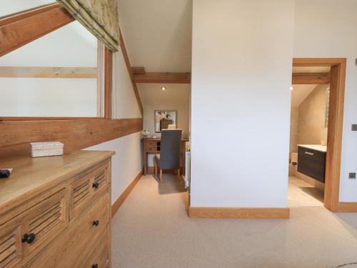 an attic kitchen with a desk and a table at Oak Cottage in Ulverston