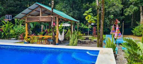 uma piscina com um gazebo ao lado de uma casa em Cabina Azul in Bejuco Beach with queen bed but no air conditioning em Bejuco