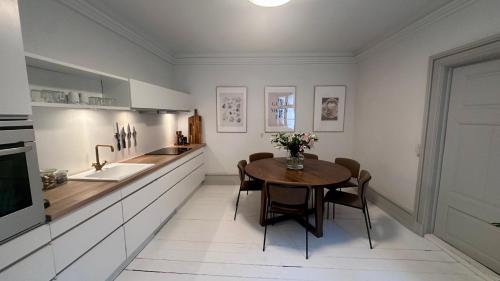 a kitchen with a table and chairs and a sink at The Admirals Apartments - Carolinas apartments in Copenhagen