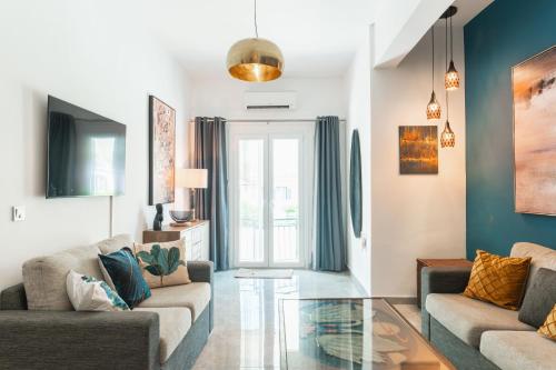a living room with two couches and a glass table at Eucalyptus Apartment Corfu Town - Starlink in Anemómylos