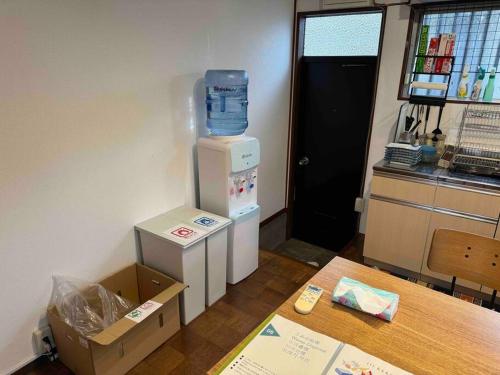 a room with a refrigerator with a water bottle on top at 『貸切、BBQ 可、送迎あり』Nonbiri Slowly Plant in Oiso