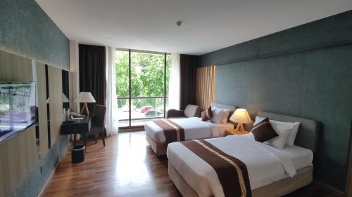 a hotel room with two beds and a window at Batam View Beach Resort in Nongsa