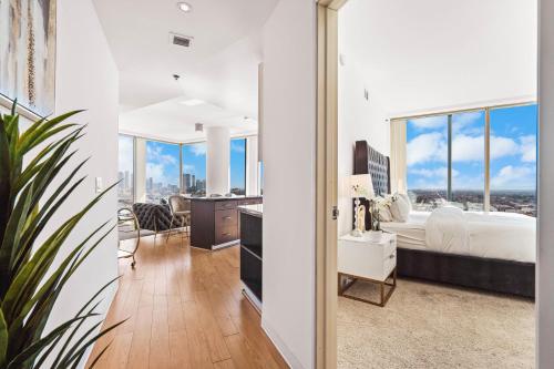 um quarto com uma cama e uma grande janela em Beautiful 2 BR Sky View Apartment em Los Angeles