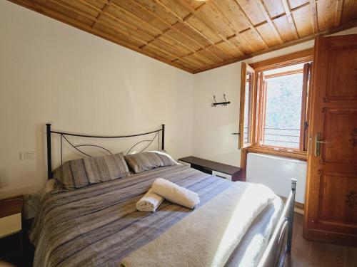 1 dormitorio con 1 cama grande y techo de madera en Grand Hotel Ceresole Reala KingApartment ideal for Nordic sport, en Ceresole Reale