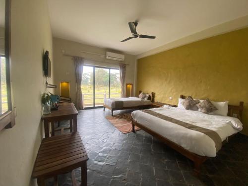 a large bedroom with two beds and a couch at River Park International Resort in Chitwan