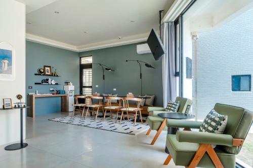 馬公市的住宿－澎湖笑掌家，客厅配有绿色椅子和桌子