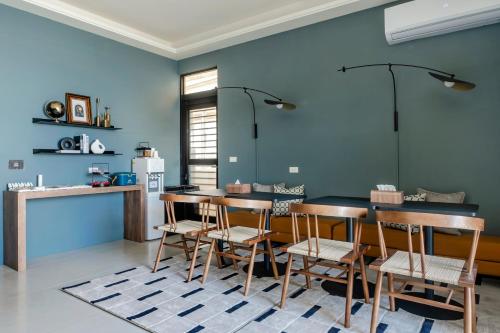 a kitchen with blue walls and a table and chairs at 澎湖笑掌家 in Magong