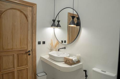 a bathroom with a sink and a mirror at Bohemian Jogja Villas with Private Pool in Kejayan