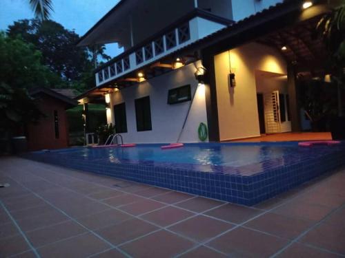 a swimming pool in front of a house at The Bird's Nest Holiday Villa Port Dickson in Port Dickson