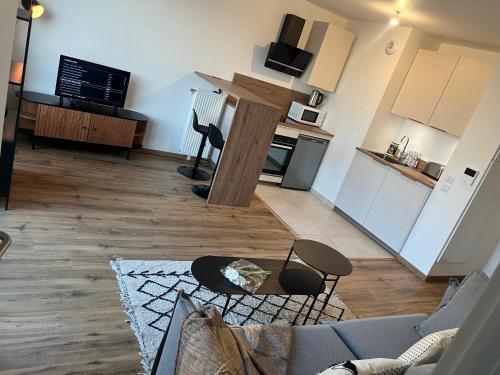 un salon avec un canapé et des chaises et une cuisine dans l'établissement Rive Urbaine, à Épinay-sur-Seine