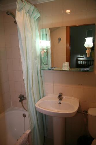 a bathroom with a sink and a shower curtain at Hostal Santa Barbara in Socuéllamos