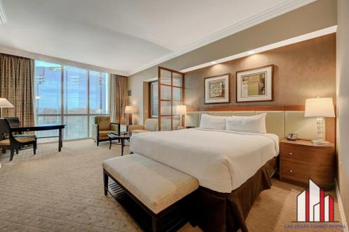 a hotel room with a large bed and a desk at MGM Signature-34-803 F1 Track & Strip View Studio in Las Vegas